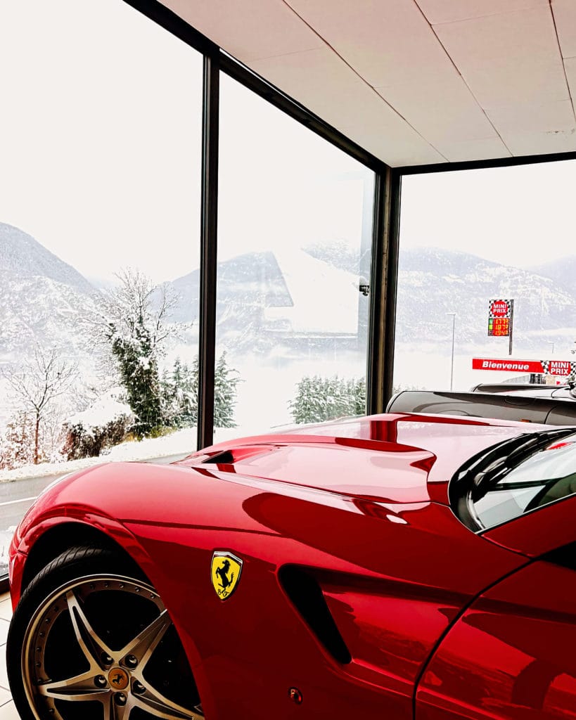 Ferrari avec vue sur montagnes enneigées au Garage du Rocher à Venthône