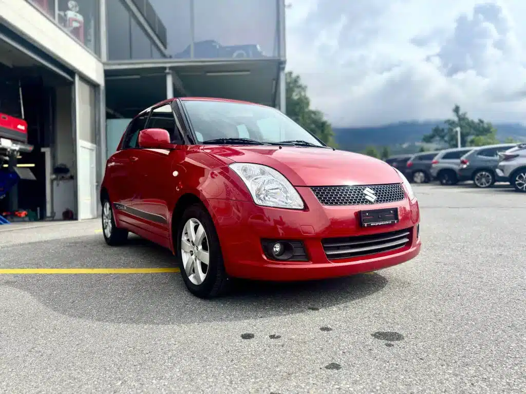 Suzuki Swift rouge à vendre devant le Garage du Rocher