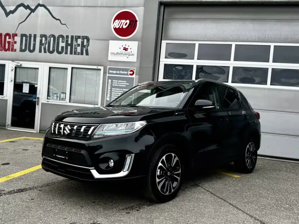 Suzuki Vitara d'occasion noir à vendre exposé devant l'entrée du Garage du Rocher, vue de profil