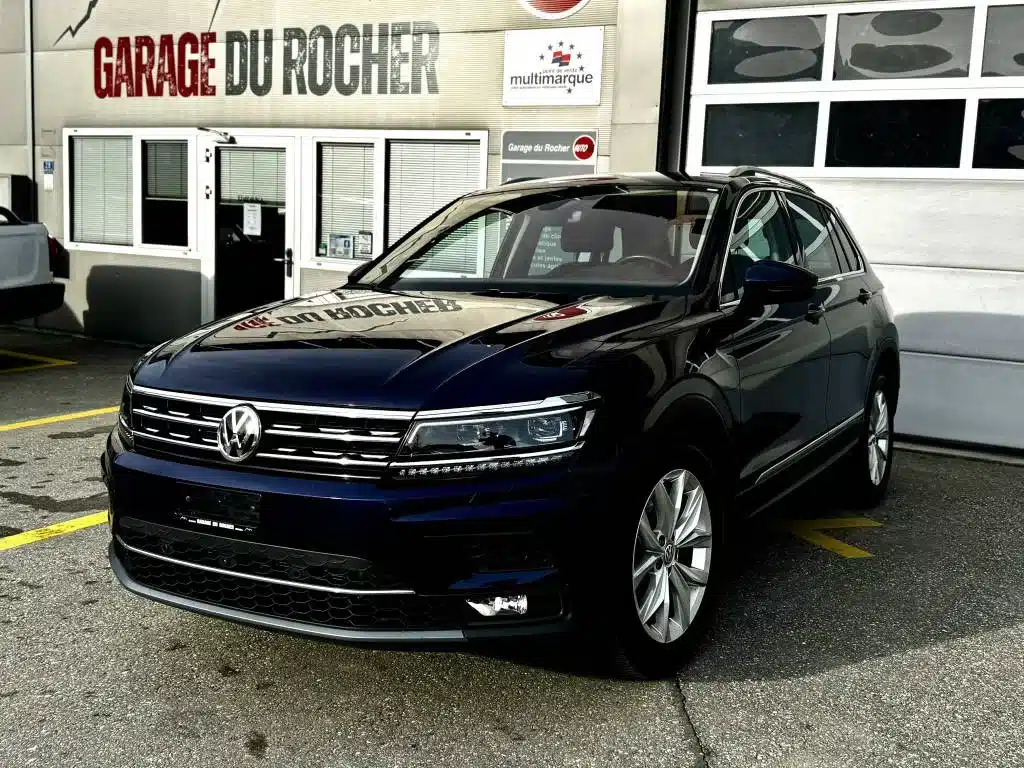 VW Tiguan 4X4 bleu d'occasion exposé devant le Garage du Rocher en Valais