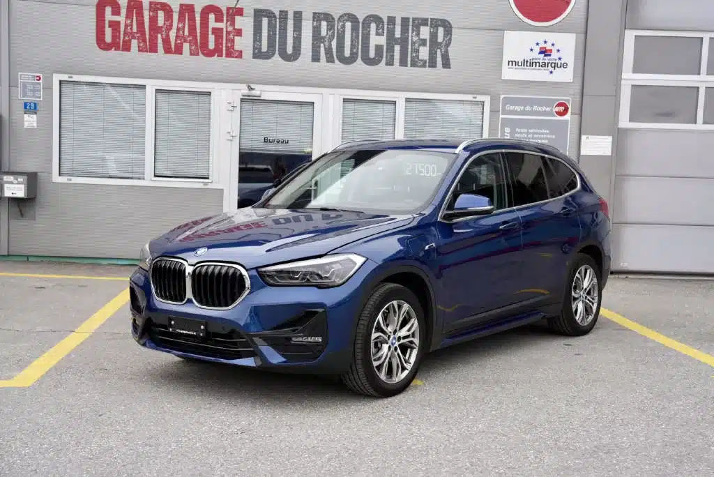 BMW X1 bleu d'occasion en expo devant le Garage du Rocher en Valais