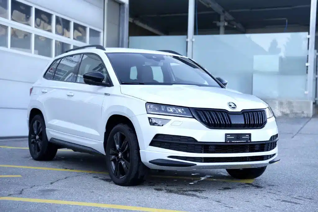 SKODA Karoq blanc d'occasion 4X4 exposé devant le Garage du Rocher en Valais